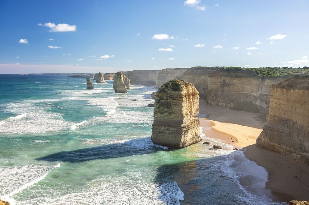The 12 Apostles surrounded by high cliffs and rough ocean.