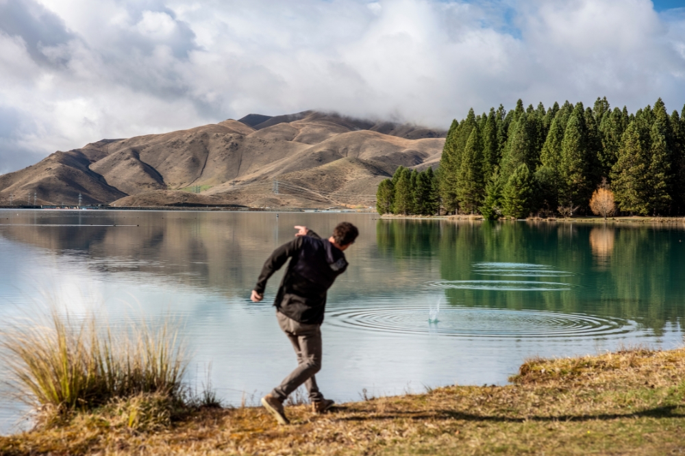 A person throws a rock into a lake