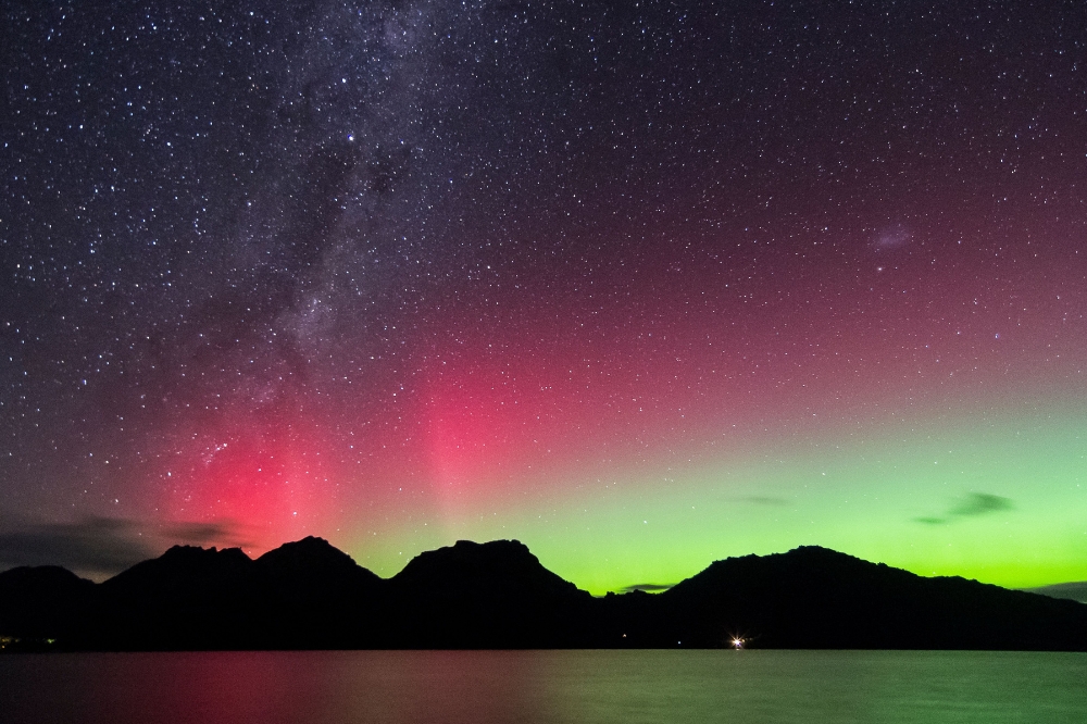 Aurora Australis in the sky with vivid pinks and greens. The stars shine through