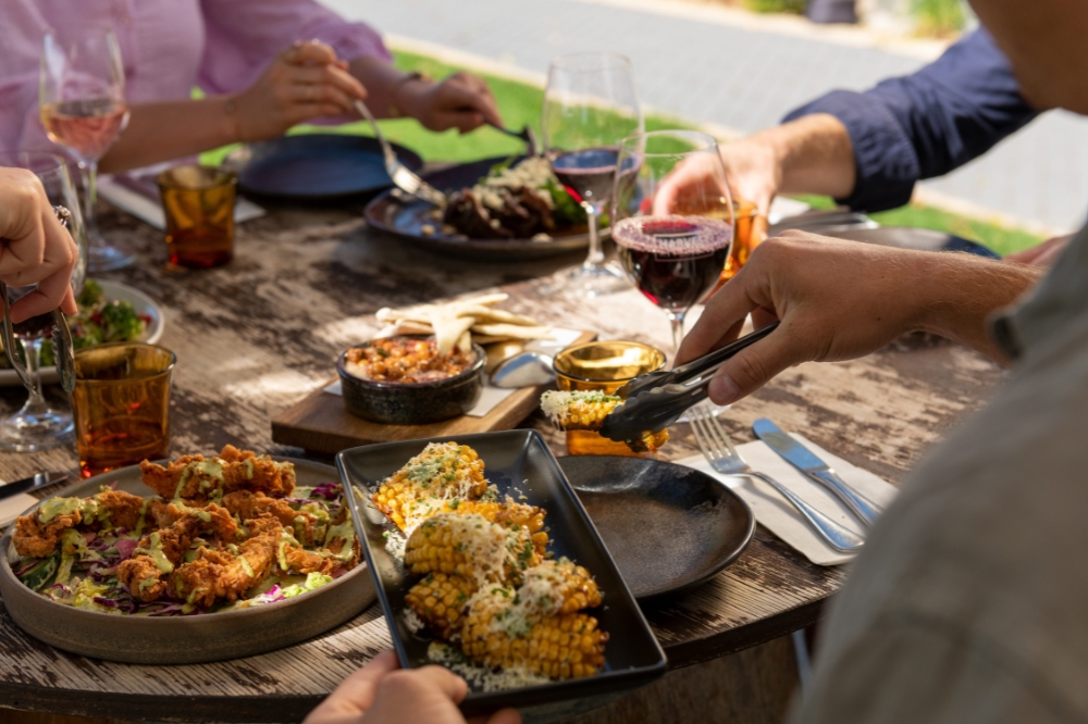 A table filled with food, people are loading their plates