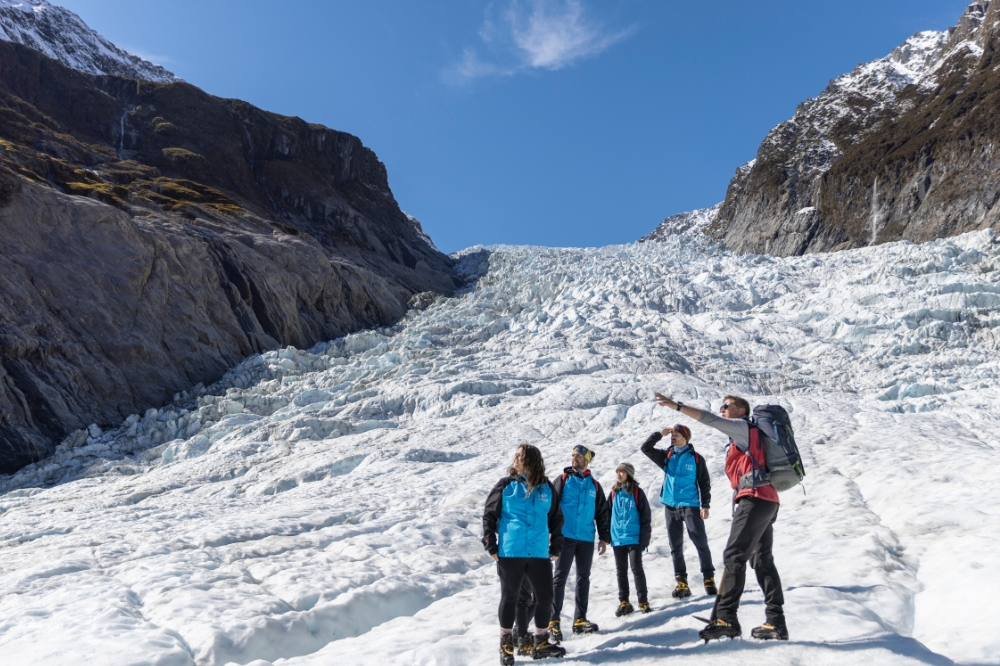 A tour group walking along a frozen glacier