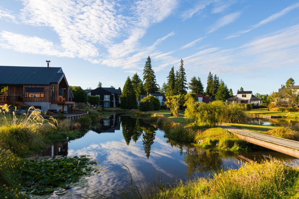 Large lodge houses surround a lake with blue skies